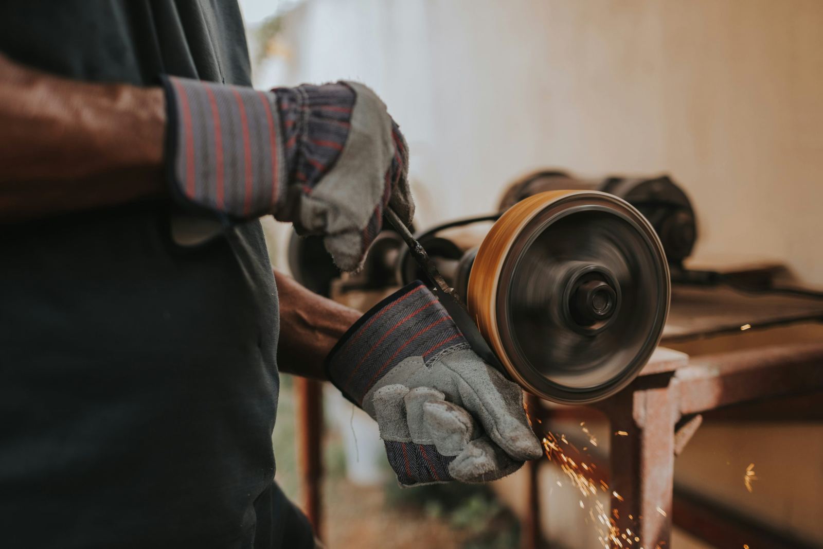 Operatore che rifinisce un profilo metallico con la smerigliatrice