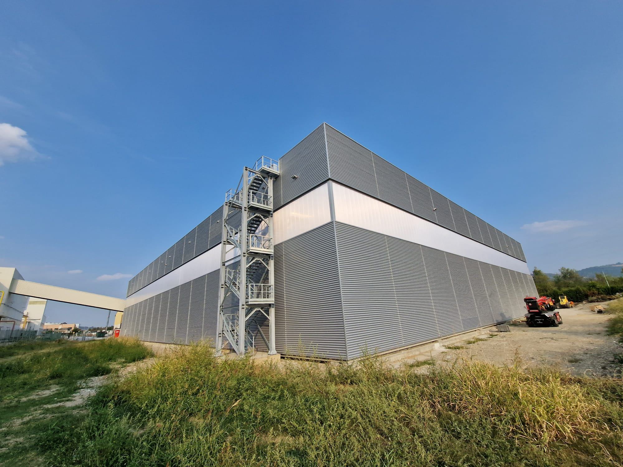 Capannone industriale con rivestimento in lamiera e scala esterna in acciaio realizzato da Kajo Costruzioni